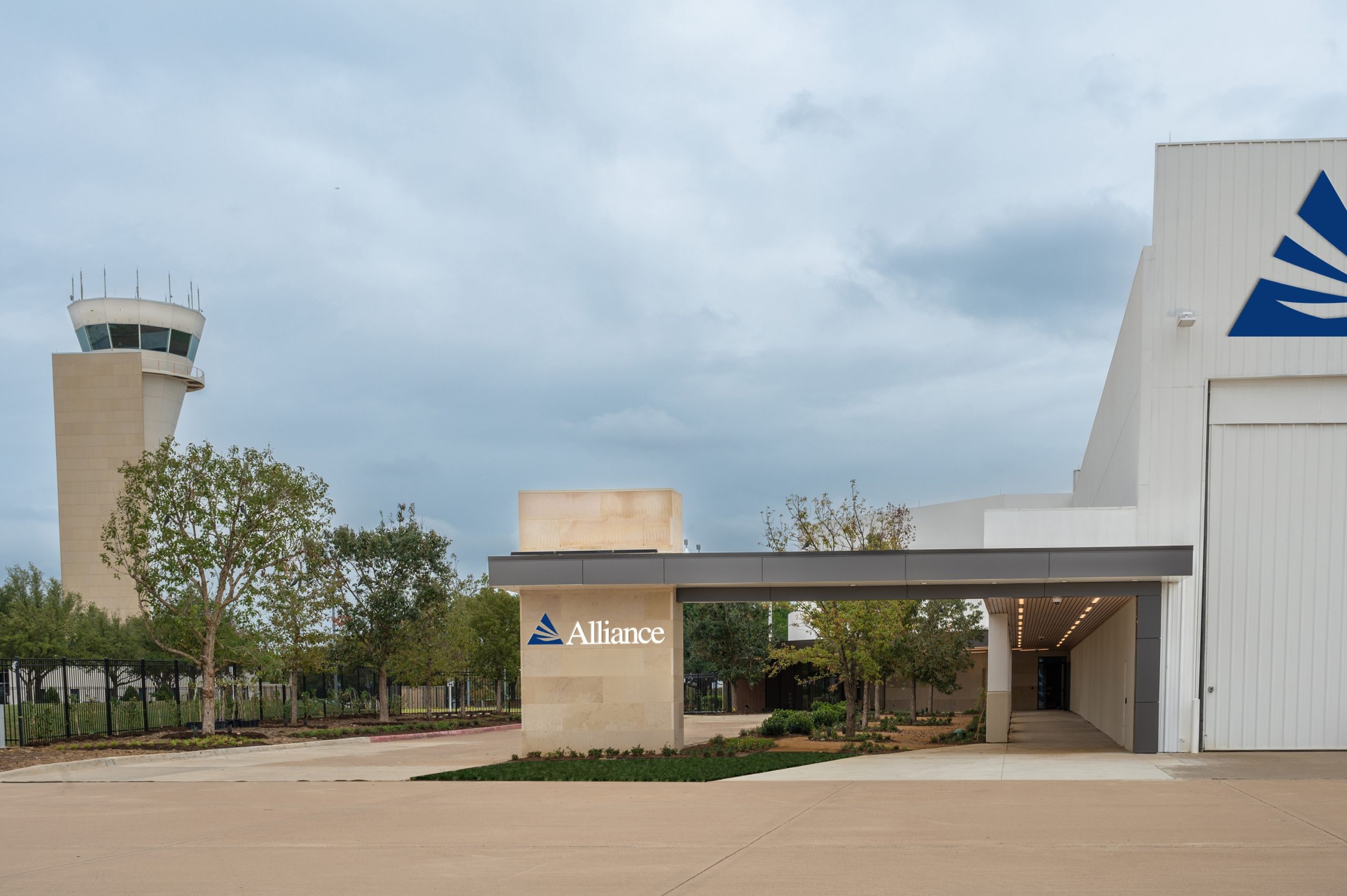 A fixed-base operation facility near an air traffic control tower is shown at Forth Worth Alliance Airport.