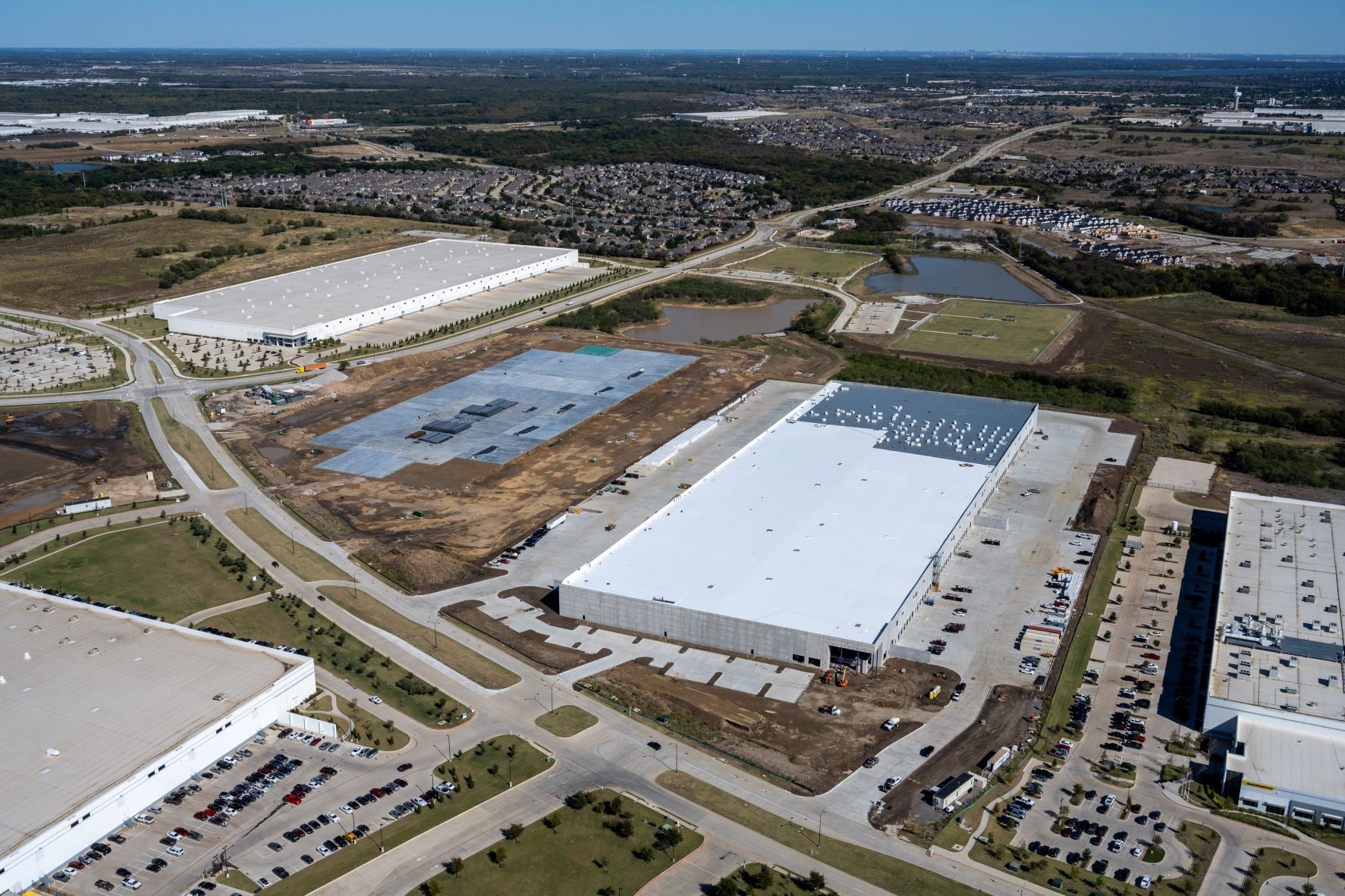 An aerial view of two white-roofed buildings at AllianceTexas, part of a distribution center for Carolina Beverage.