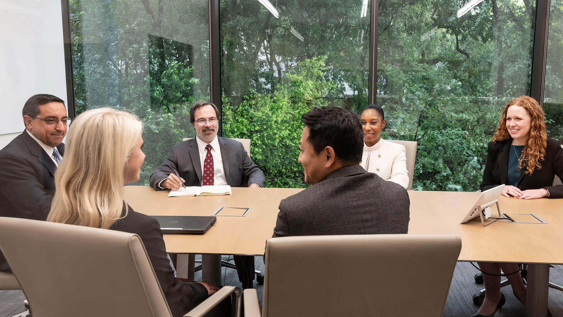 Three men and three women surround a conference table.