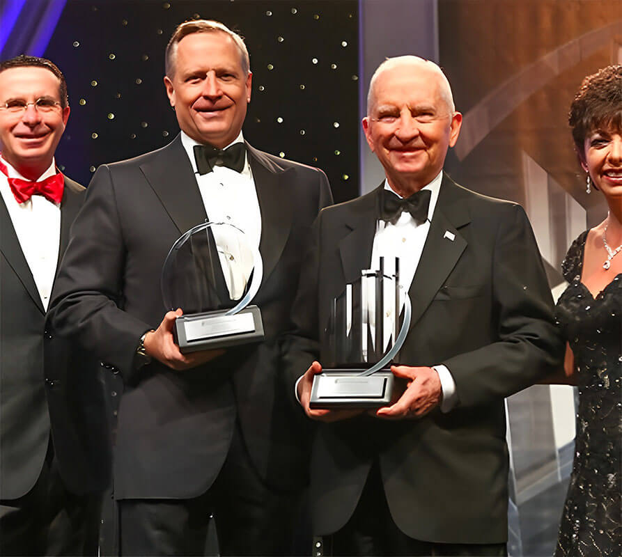 Ross Perot Jr. and Ross Perot Sr. are in tuxedoes as they receive Ernst & Young’s Family Business Award of Excellence.