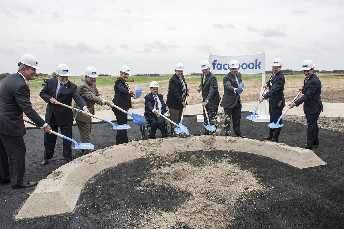 Ten people with hard hats and shovels break ground on a Facebook data center at AllianceTexas.