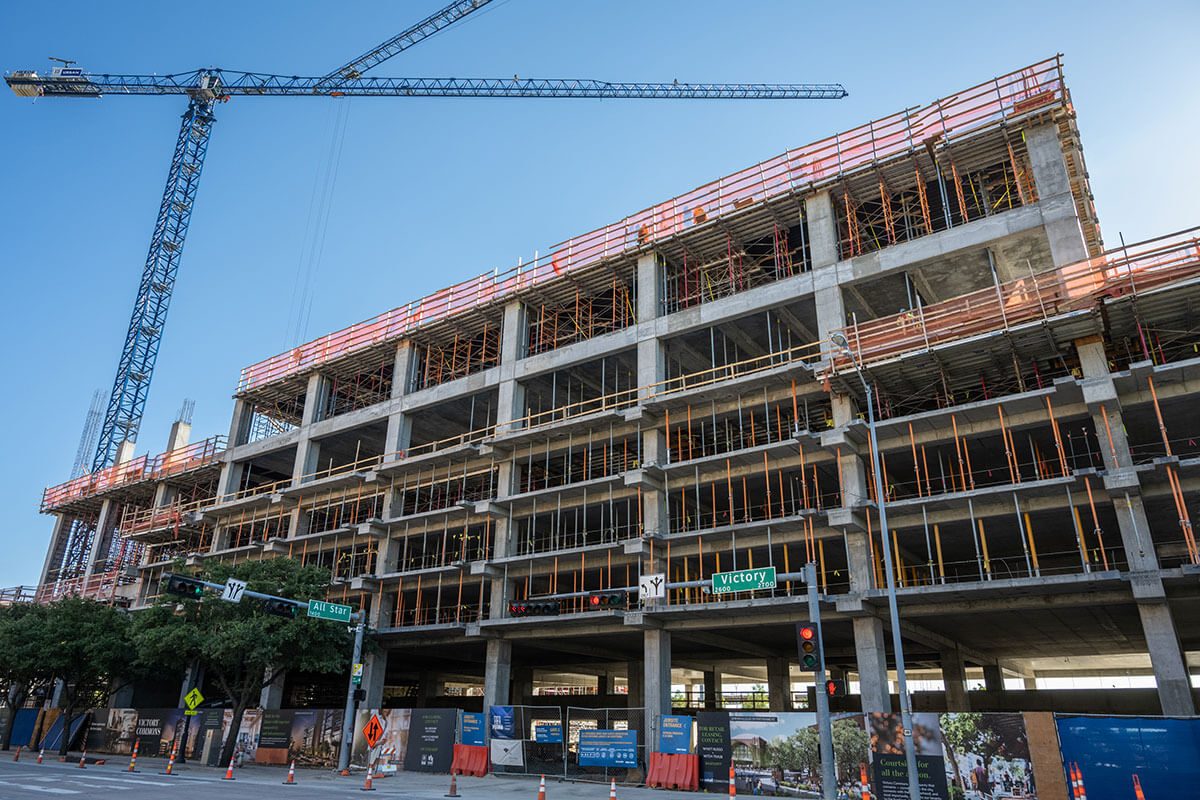 A crane hovers over a building under construction at Victory Park in Dallas, Texas.