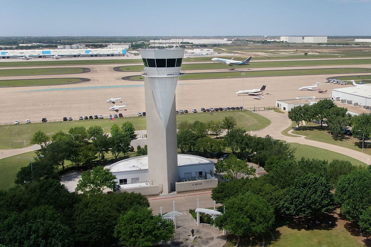 A jet takes off from Alliance Airport. An air-traffic control tower is seen in the foreground.