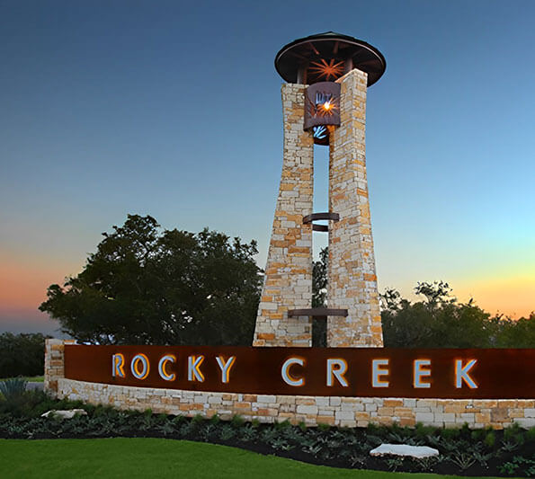 A long stone sign reading, 'Rocky Creek' in Austin, Texas.